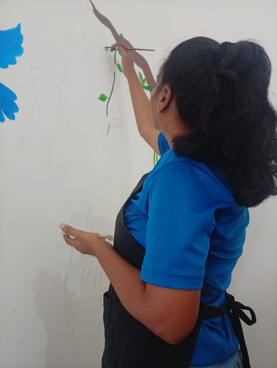 Nimesha DishAni — painting a mural